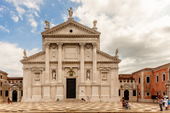 tourists stroll in front of the Basilica of San Giorgio Maggiore in Venice, front view.